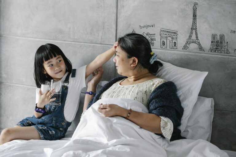 Adorable Asian kid touching forehead of sick grandmother